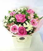 Hand tied bouquet in soft pinks and whites including roses, germini and chrysanthemums. 